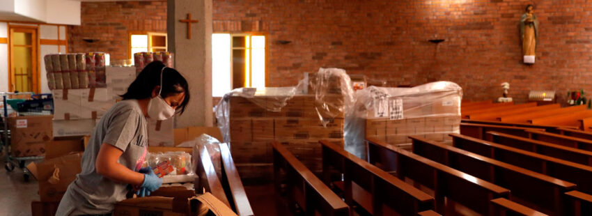 Una voluntaria organiza un lote de alimentos en la parroquia de Nuestra Señora de Bellvitge que la