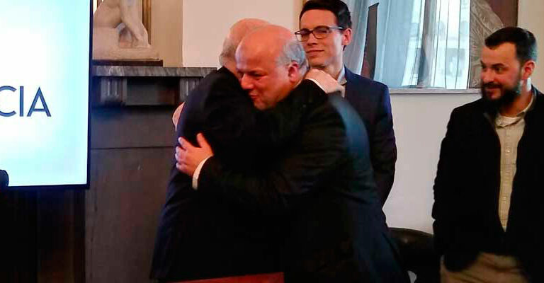 El cardenal arzobispo de Madrid, Carlos Osoro, se abraza con el secretario de la Comisión